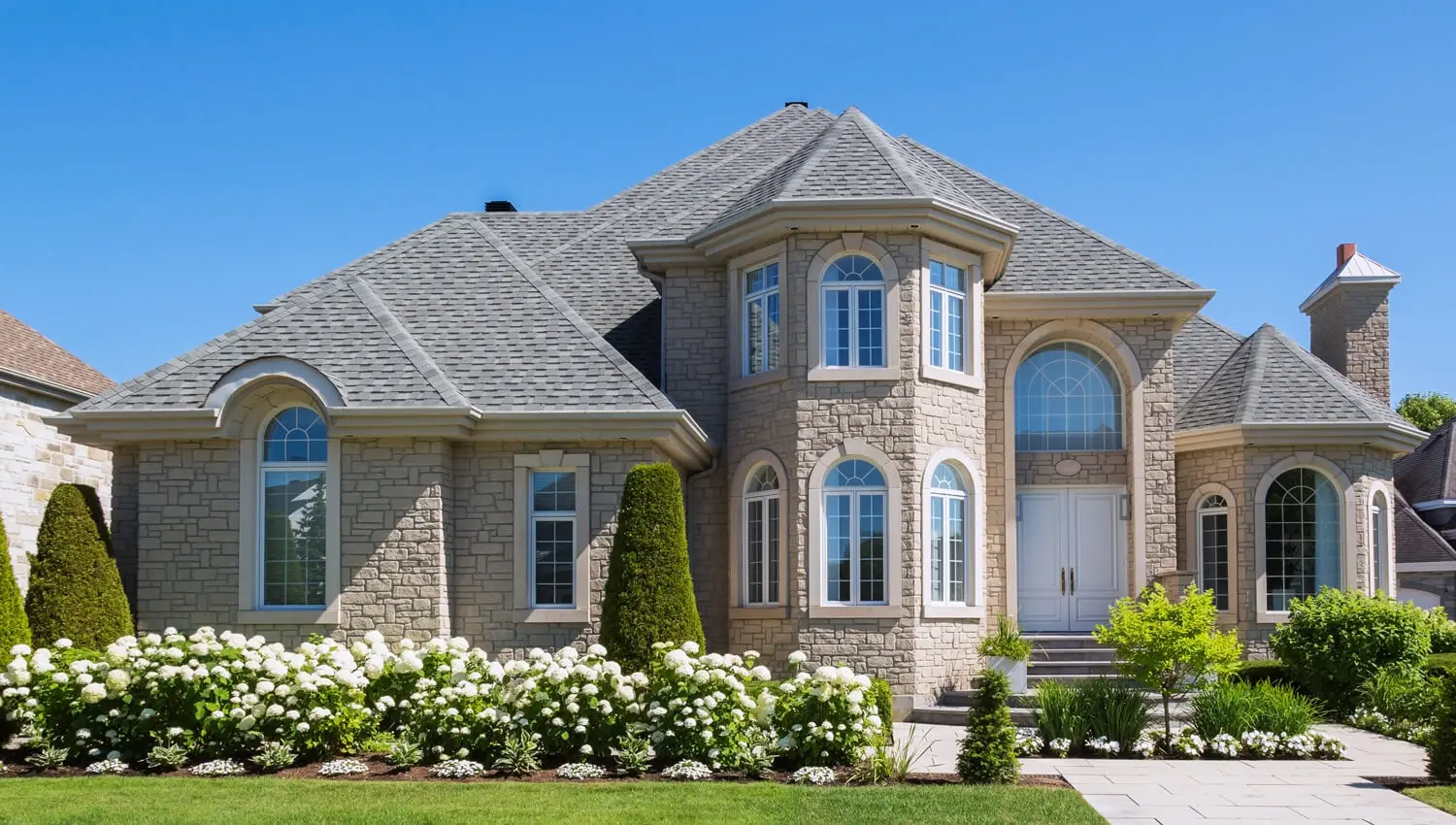areas-Choctaw- OK Exterior painting of a luxury stone house with elegant arched windows in Oklahoma City, OK
