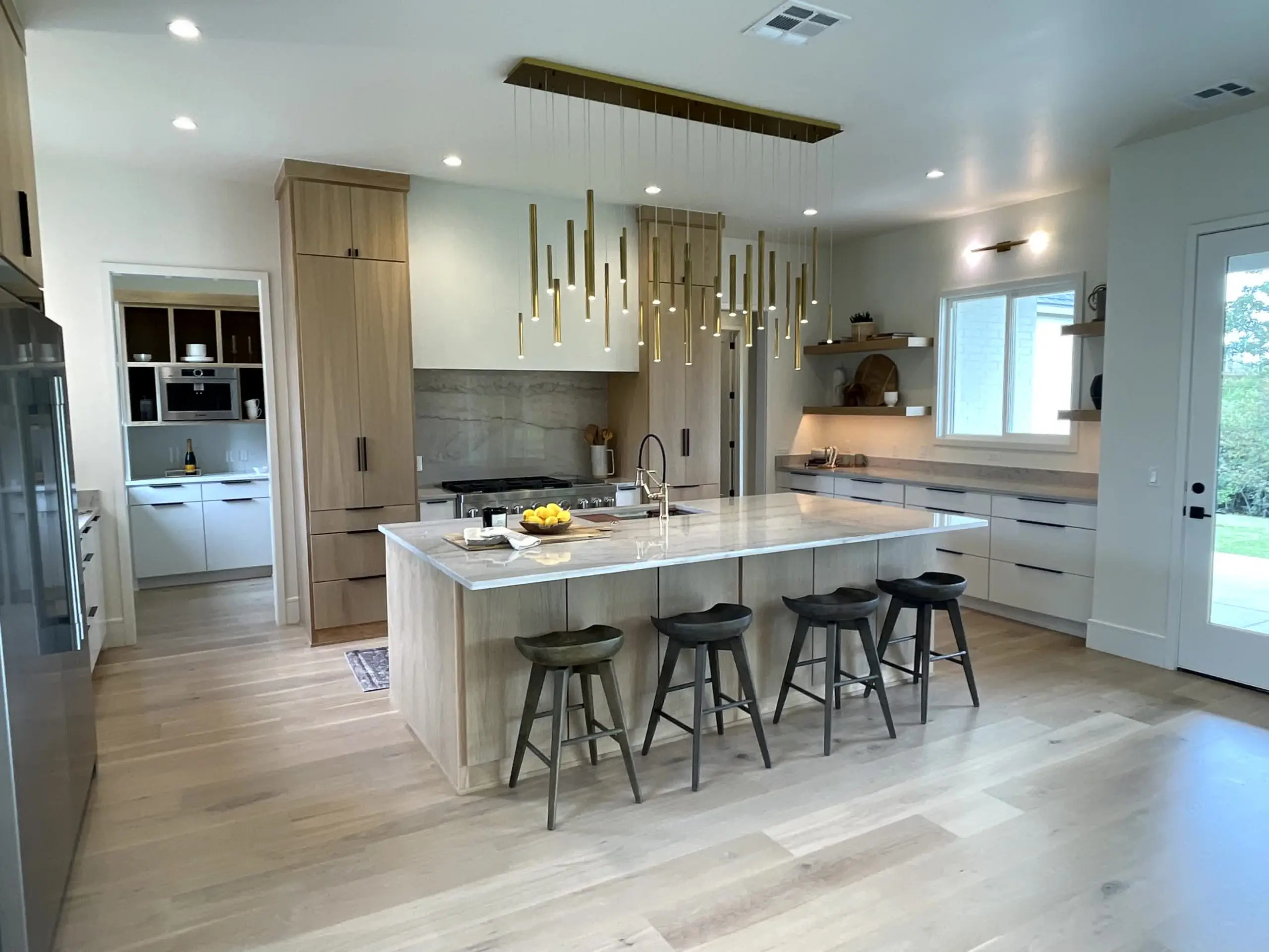 project-gallery-interior-painting-01 Modern kitchen with wood cabinetry, marble island, and gold pendant lighting in Newcastle, OK