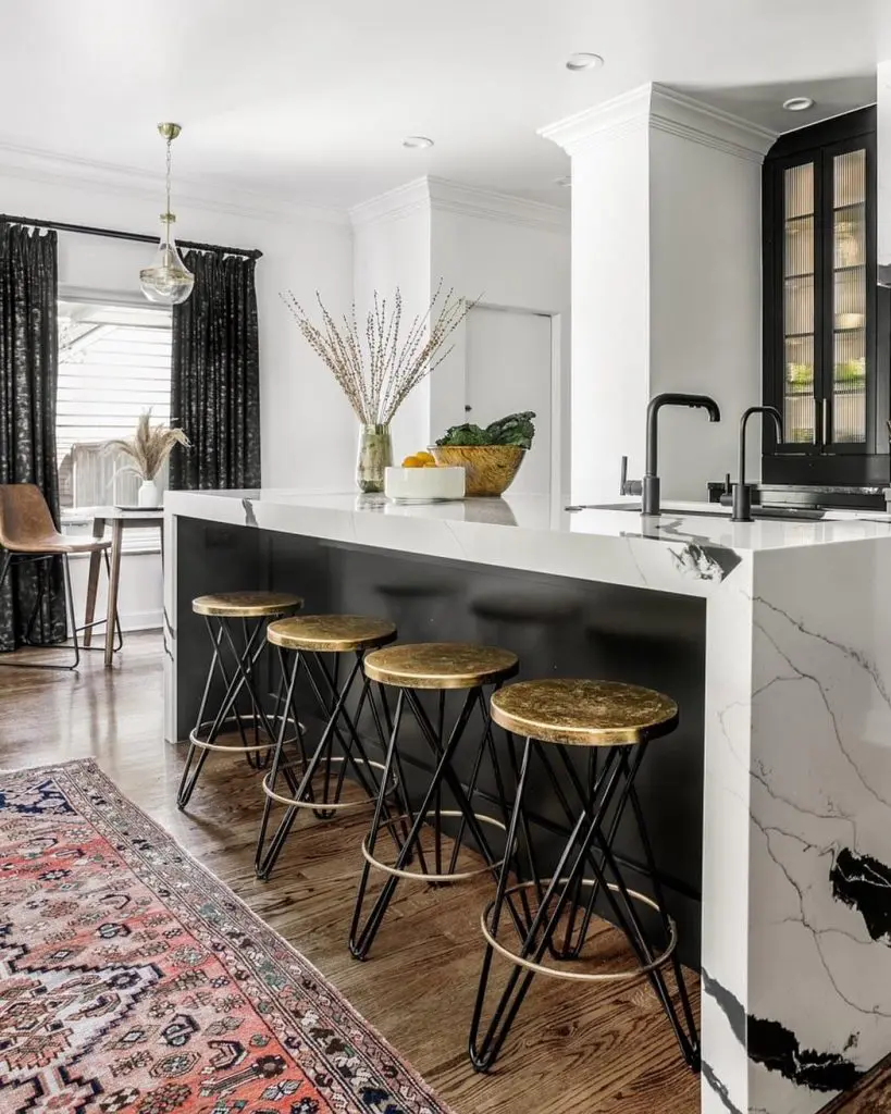 Modern kitchen with marble island, black cabinets, and bar stools in Oklahoma City
