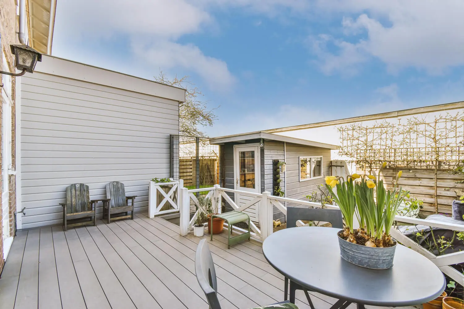 service-deck-and-staining-okc Backyard deck with painted wood fencing and garden seating in Newcastle, O