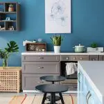 Modern kitchen with blue walls and clean surfaces, showing how to prepare your home for professional interior painting before painters arrive.