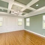 Freshly painted living room with green walls and white trim, showing how interior paint finish choice affects maintenance and durability in everyday spaces