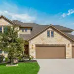 Two-story stone and stucco home exterior in Oklahoma City with a professionally painted finish.