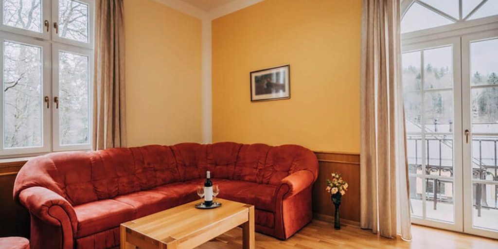 Interior painting for older homes with warm yellow walls, wood trim, and classic living room furnishings.