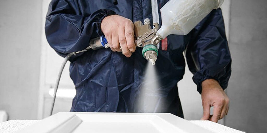 Professional cabinet painting cost shown through spray application on kitchen cabinet doors